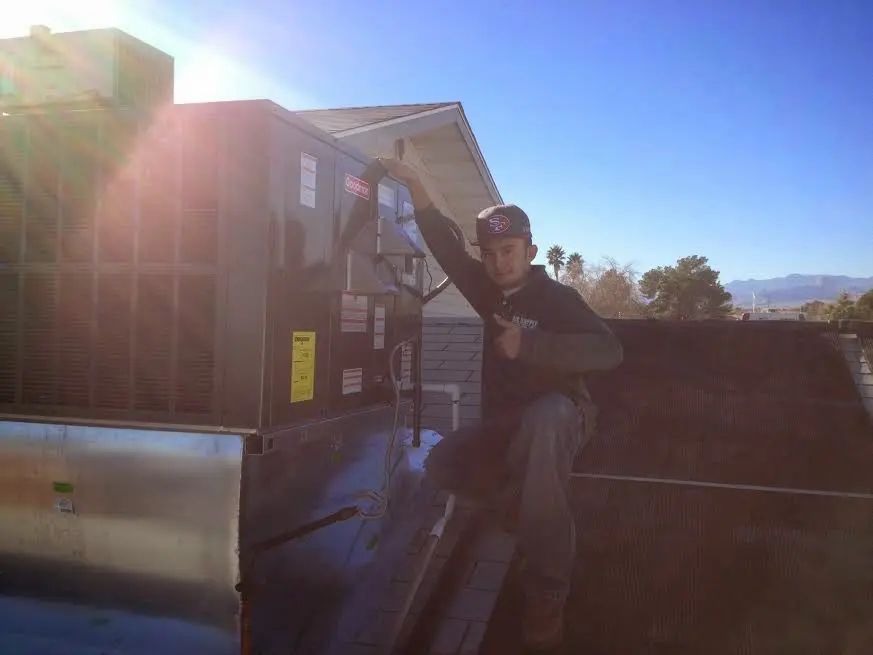 HVAC technician performing HVAC Inspection on a rooftop unit in Rapid City